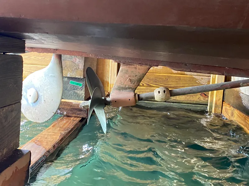 Slide: The Image of Propeller and rudder of 1962 Lyman 24 Sleeper Hardtop boat in water. - 26