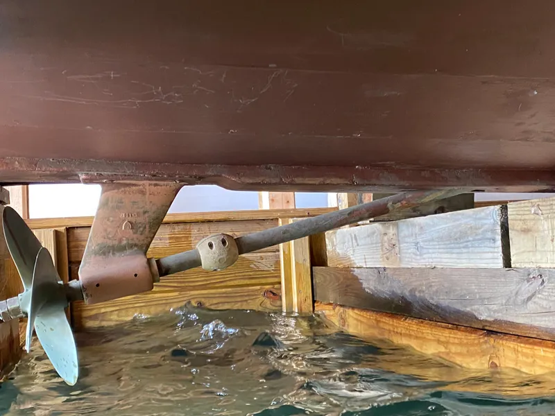 Slide: The Image of 1962 Lyman 24 Sleeper Hardtop boat propeller and shaft in water. - 27