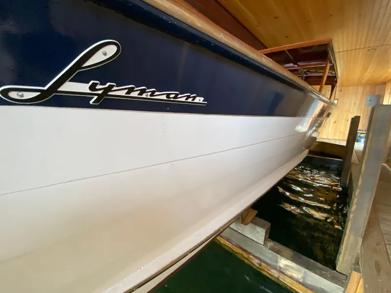 Slide: The Image of 1962 Lyman 24 Sleeper Hardtop boat docked in wooden boathouse. - 28
