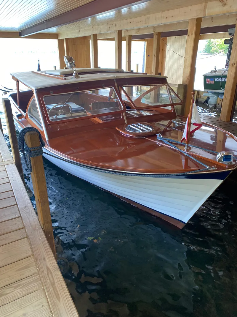Slide: The Image of 1962 Lyman 24 Sleeper Hardtop boat docked in a wooden boathouse. - 3