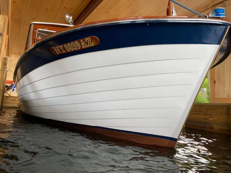 Slide: The Image of 1962 Lyman 24 Sleeper Hardtop boat in wooden boathouse, side view. - 4