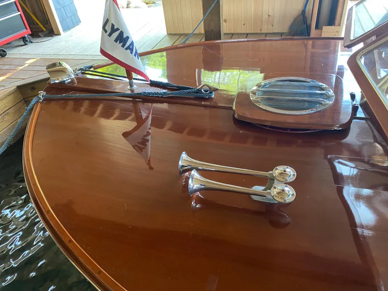 Slide: The Image of 1962 Lyman 24 Sleeper Hardtop boat with polished wood deck and chrome details. - 9