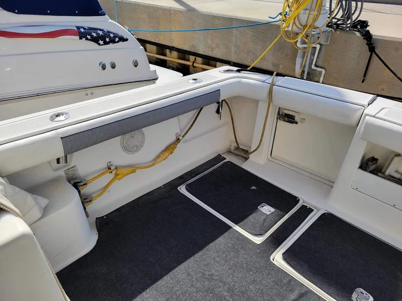 Slide: The Image of 1995 Tiara Yachts 3100 Open boat interior with American flag detail and docked ropes. - 4