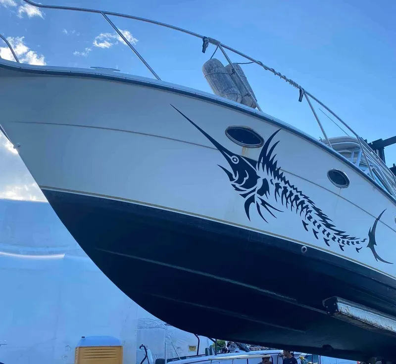 Slide: The Image of 1995 Tiara Yachts 3100 Open with marlin graphic on hull, docked under blue sky. - 8