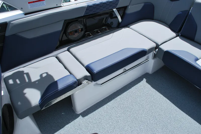 Slide: The Image of 2024 MasterCraft XT24 boat interior with blue and gray seating and speaker system. - 8