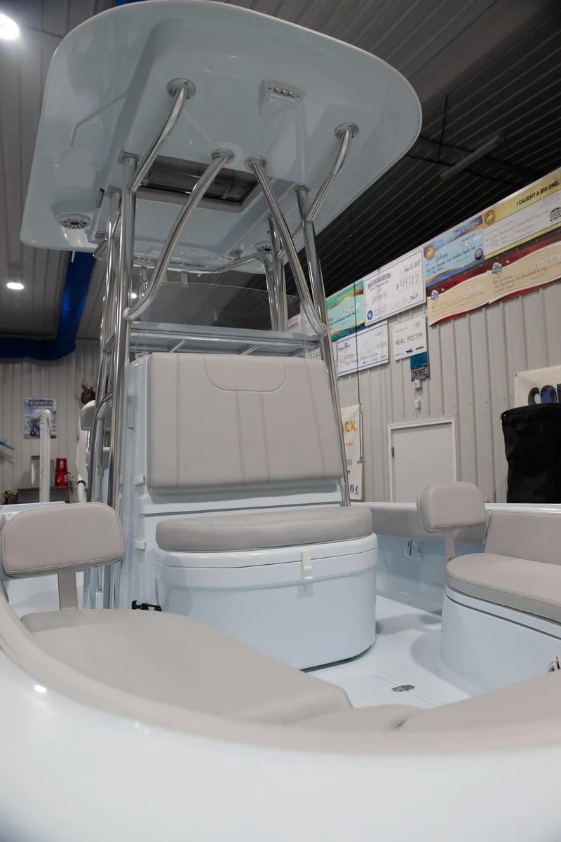 Slide: The Image of 2024 Contender 26 Bay boat interior with seating and T-top in showroom. - 10
