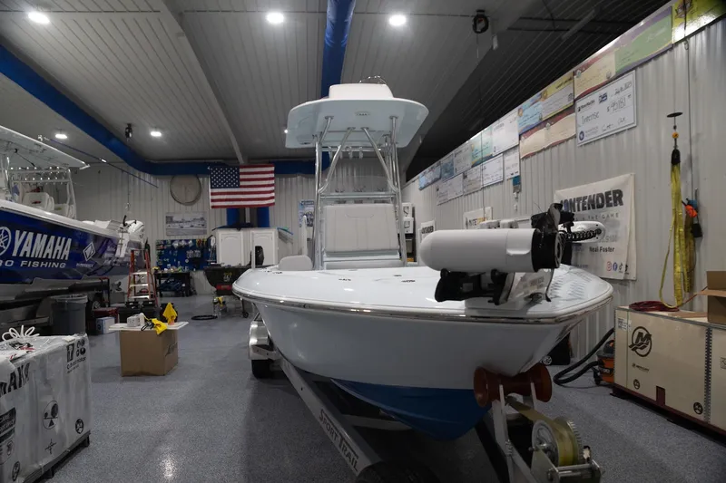 Slide: The Image of 2024 Contender 26 Bay boat in showroom with American flag and Yamaha branding. - 2