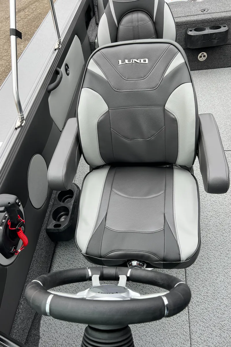 Slide: The Image of 2025 Lund 1975 Tyee boat interior with gray seating and steering wheel. - 23