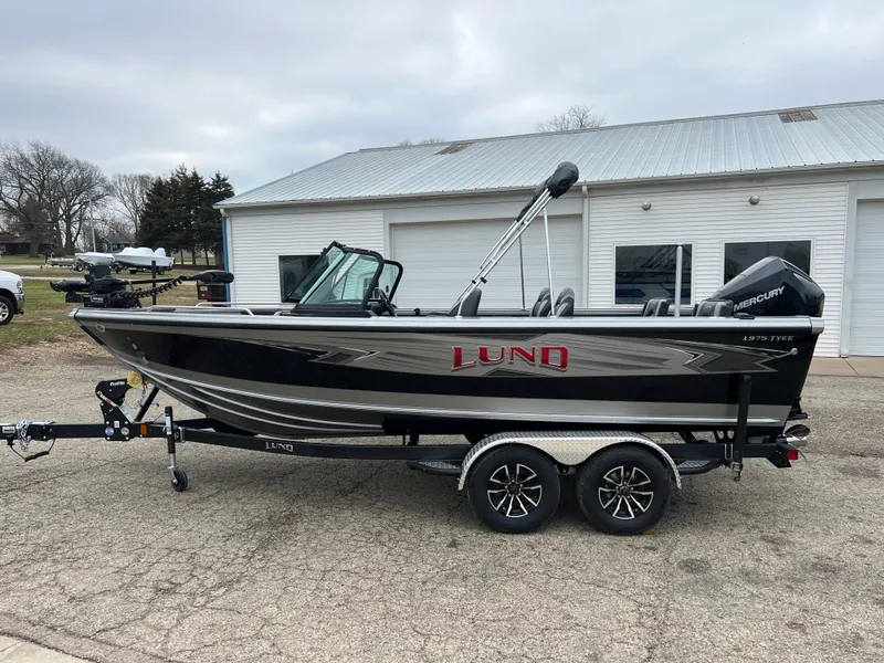 Slide: The Image of 2025 Lund 1975 Tyee boat on trailer, parked outside a building. - 3