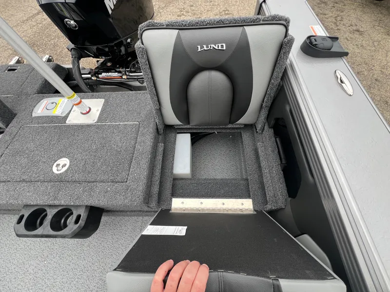 Slide: The Image of Lund 1975 Tyee 2025 boat seat with storage compartment and motor in background. - 36