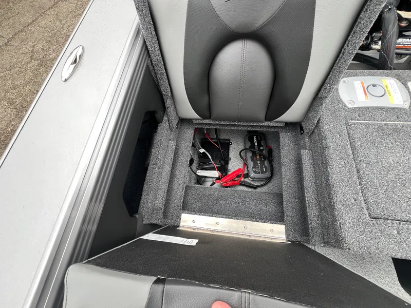 Slide: The Image of Lund 1975 Tyee 2025 boat seat with storage compartment and battery cables. - 37