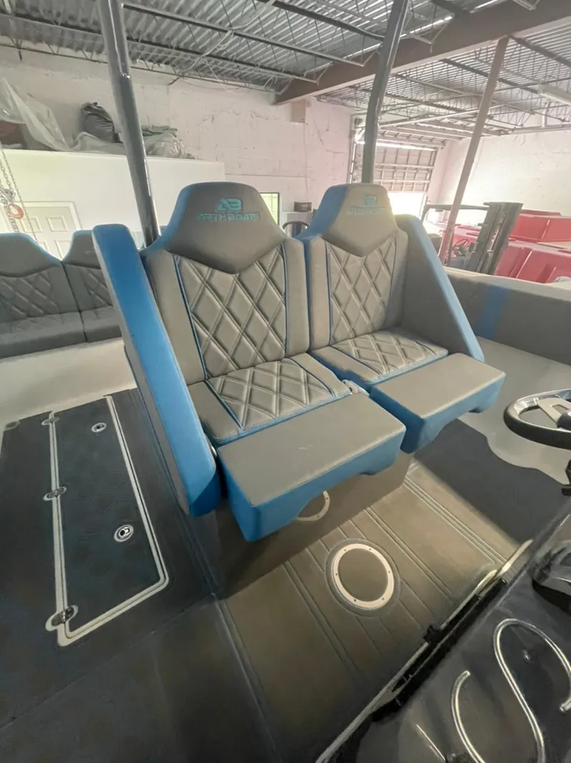 Slide: The Image of AMP 333 boat interior, 2021 model, featuring blue and gray quilted seats in a spacious cabin. - 21