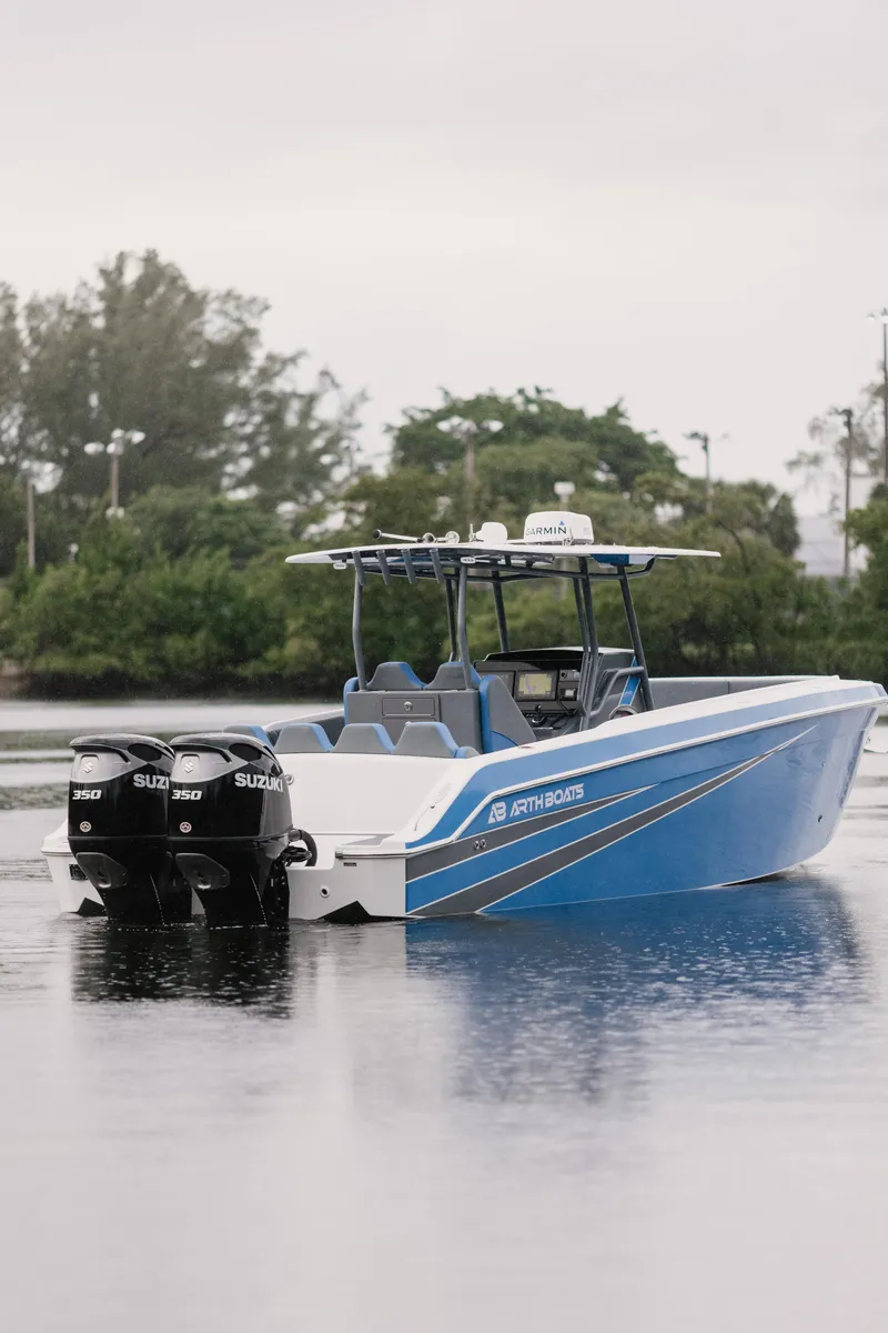 Slide: The Image of Blue AMP 333 boat with dual Suzuki engines on a calm lake, 2021 model. - 3