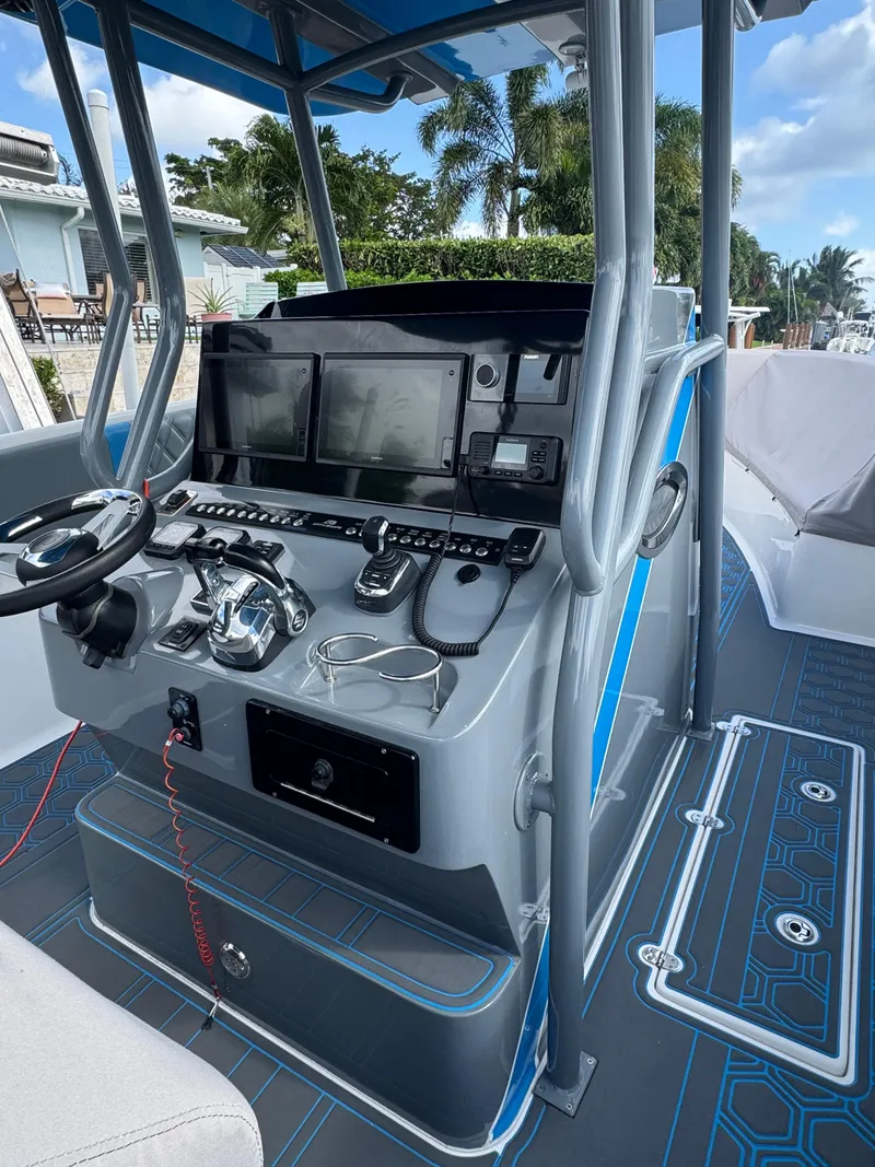 Slide: The Image of Modern AMP 333 boat console with advanced navigation equipment, 2021 model, docked near palm trees. - 4