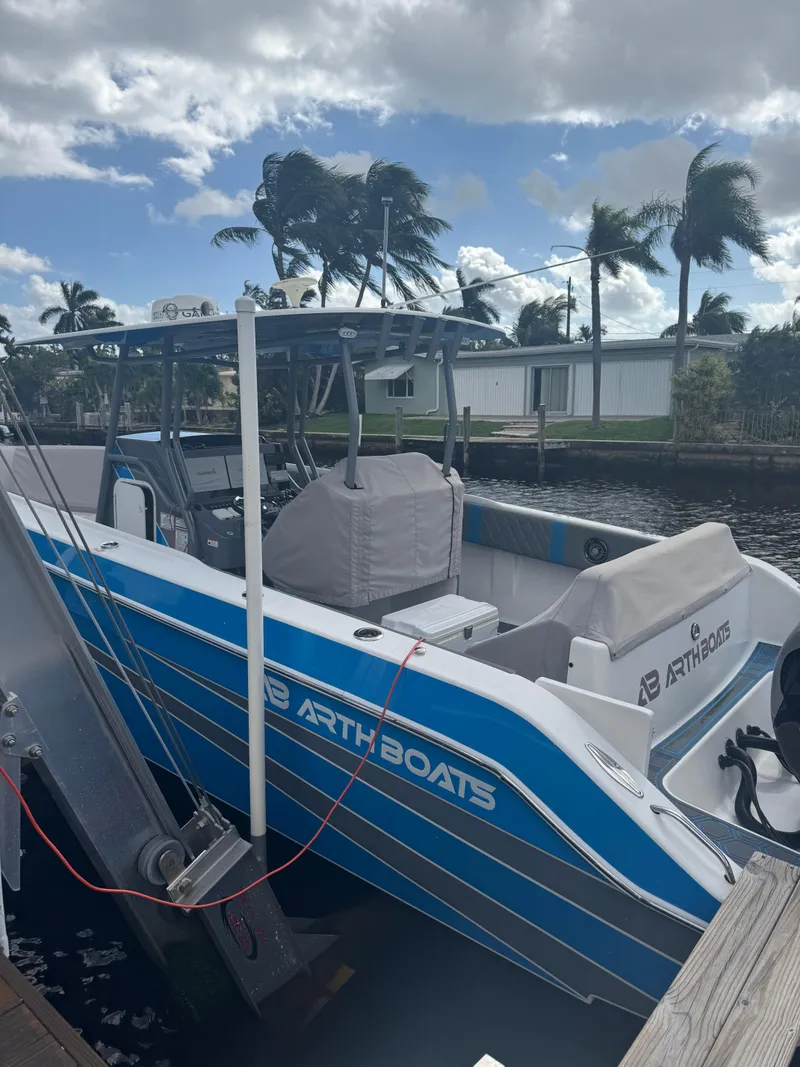 Slide: The Image of Blue and white AMP 333 boat docked, 2021 model, with palm trees in the background. - 6