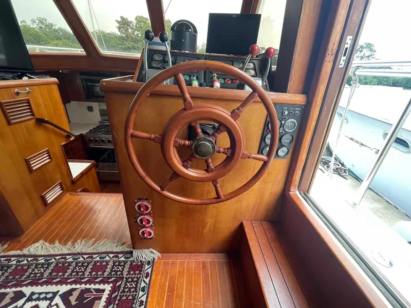 Slide: The Image of Wooden helm of 1987 Hartman-Palmer 38 yacht with nautical controls and instruments. - 40