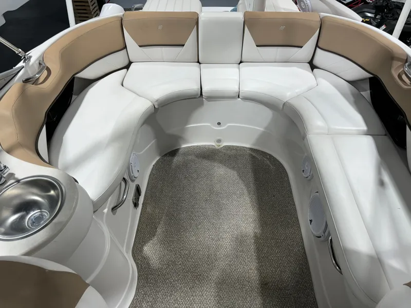 Slide: The Image of 2012 Four Winns H260 boat interior with white and beige seating and a built-in sink. - 12