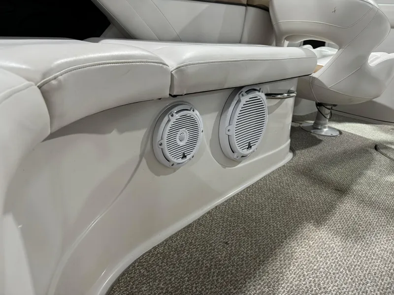 Slide: The Image of 2012 Four Winns H260 boat interior with speakers and cushioned seating. - 15