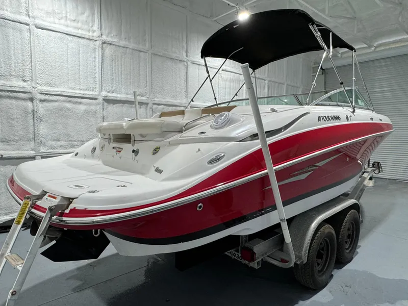 Slide: The Image of 2012 Four Winns H260 boat with red and white design on a trailer in a garage. - 3