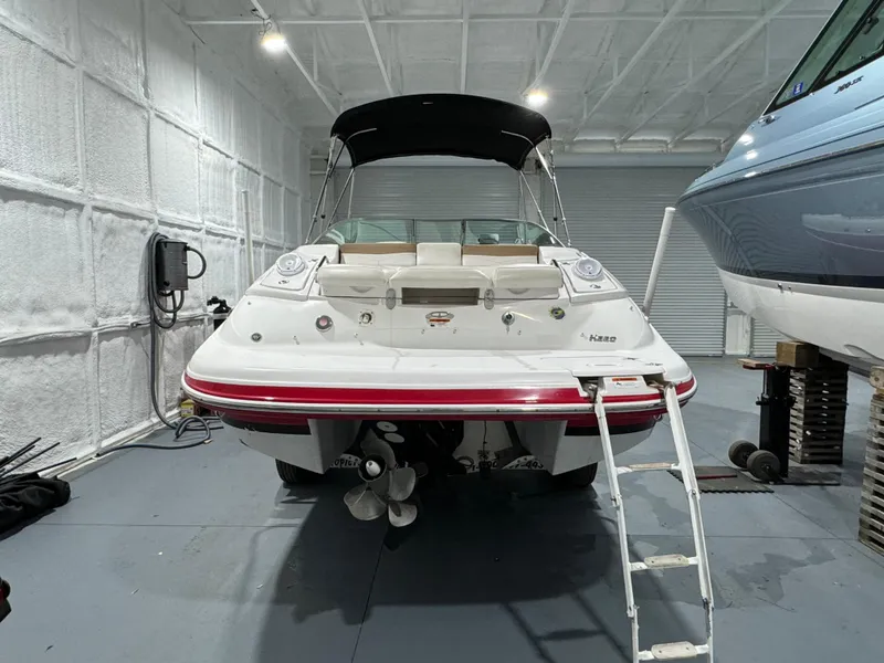 Slide: The Image of 2012 Four Winns H260 boat in storage, rear view with ladder and propeller visible. - 4