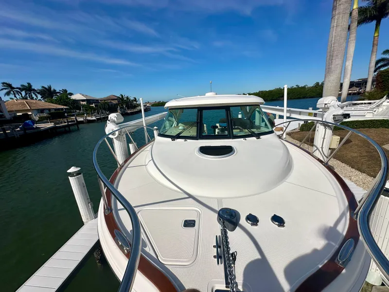 Slide: The Image of 2012 Tiara Yachts 3100 Coronet docked by waterfront homes under clear blue sky. - 10