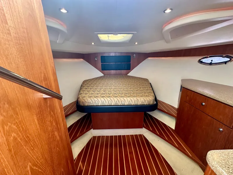 Slide: The Image of Luxurious cabin interior of 2012 Tiara Yachts 3100 Coronet with wood accents and cozy bed. - 24