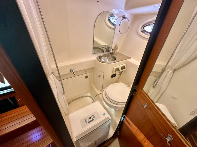 Slide: The Image of Compact bathroom in 2012 Tiara Yachts 3100 Coronet with sink, toilet, and mirror. - 28