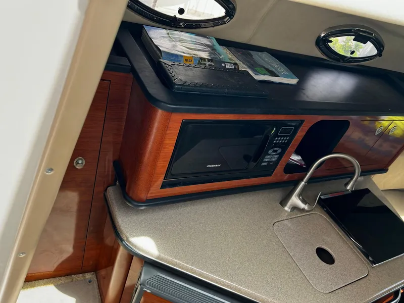 Slide: The Image of 2006 Sea Ray 260 Sundancer cabin kitchen with microwave and sink. - 3