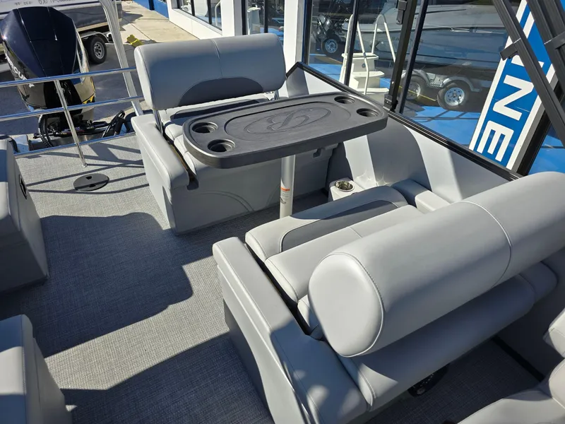 Slide: The Image of 2025 Bentley Pontoons 223 Quad Swingback Legacy Tritoon interior with gray seating and table. - 9