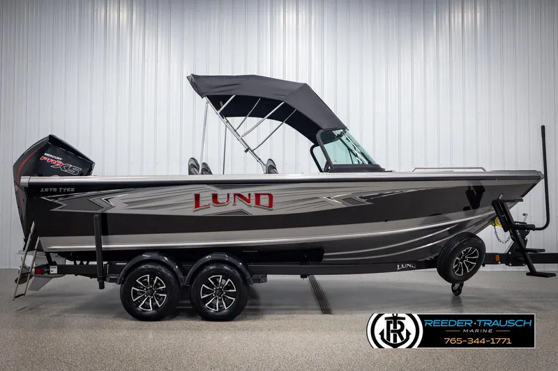 Slide: The Image of 2025 Lund 1975 Tyee boat with canopy, displayed indoors on a trailer. - 4