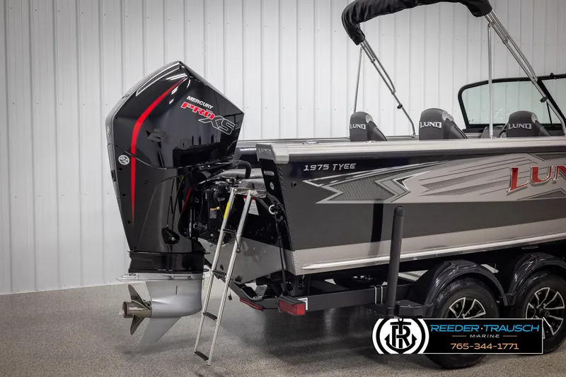 Slide: The Image of 2025 Lund 1975 Tyee boat with powerful outboard motor in showroom. - 42