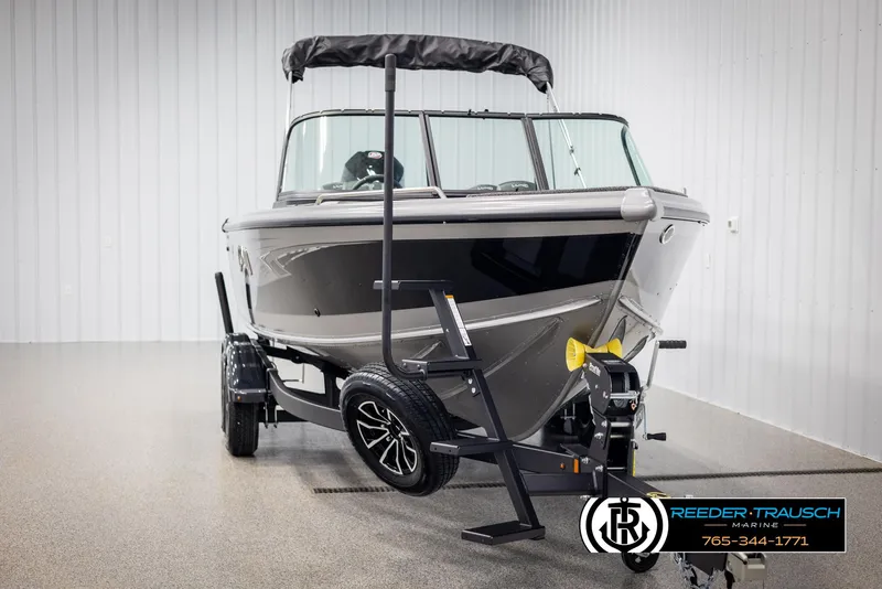 Slide: The Image of 2025 Lund 1975 Tyee boat on trailer in showroom, Reeder-Trausch Marine logo visible. - 48