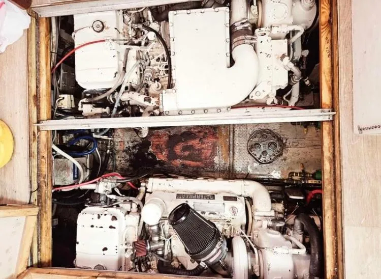 Slide: The Image of Engine room of 1975 Hatteras 36 Convertible boat, showcasing dual engines and mechanical components. - 10