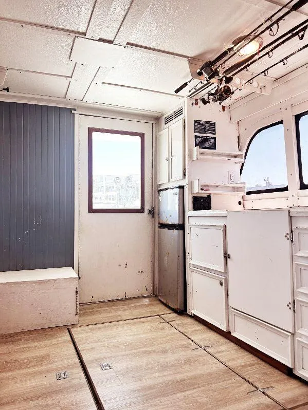 Slide: The Image of Interior of 1975 Hatteras 36 Convertible boat with white cabinetry and wood flooring. - 11