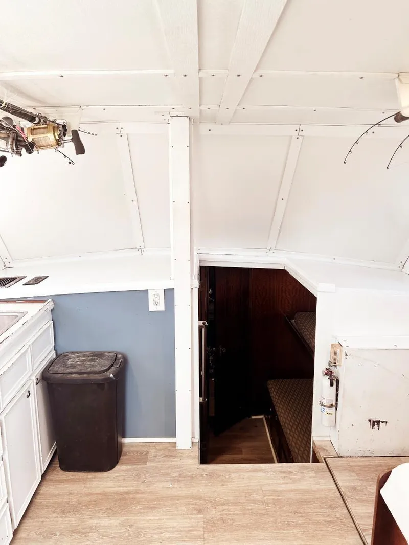 Slide: The Image of Interior of 1975 Hatteras 36 Convertible boat, featuring white cabinetry and wooden flooring. - 12