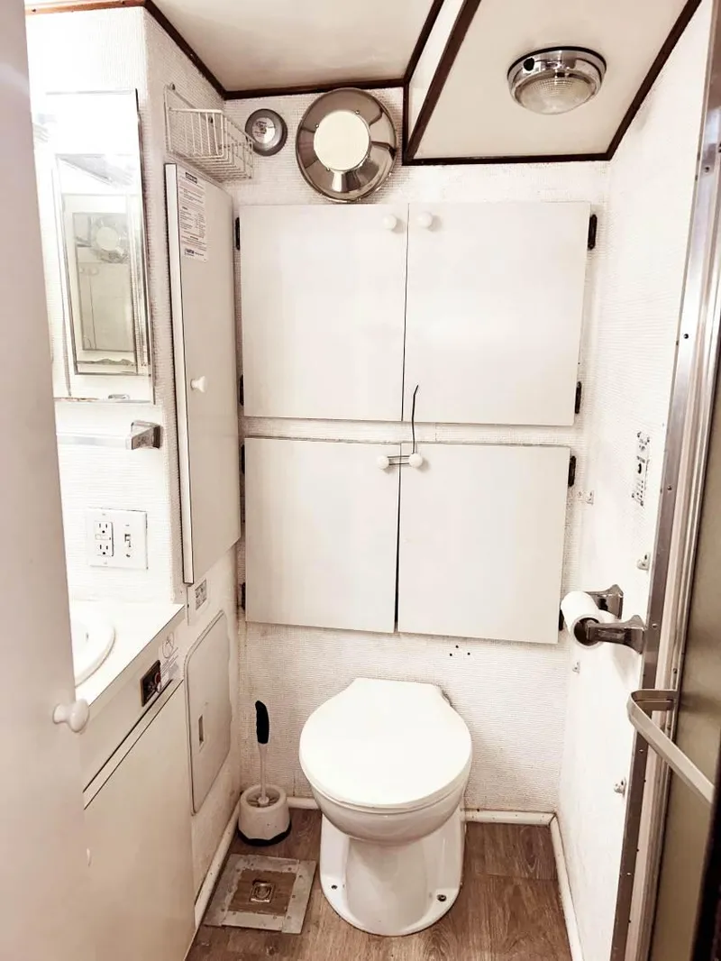 Slide: The Image of 1975 Hatteras 36 Convertible yacht bathroom with white cabinetry and wood flooring. - 13