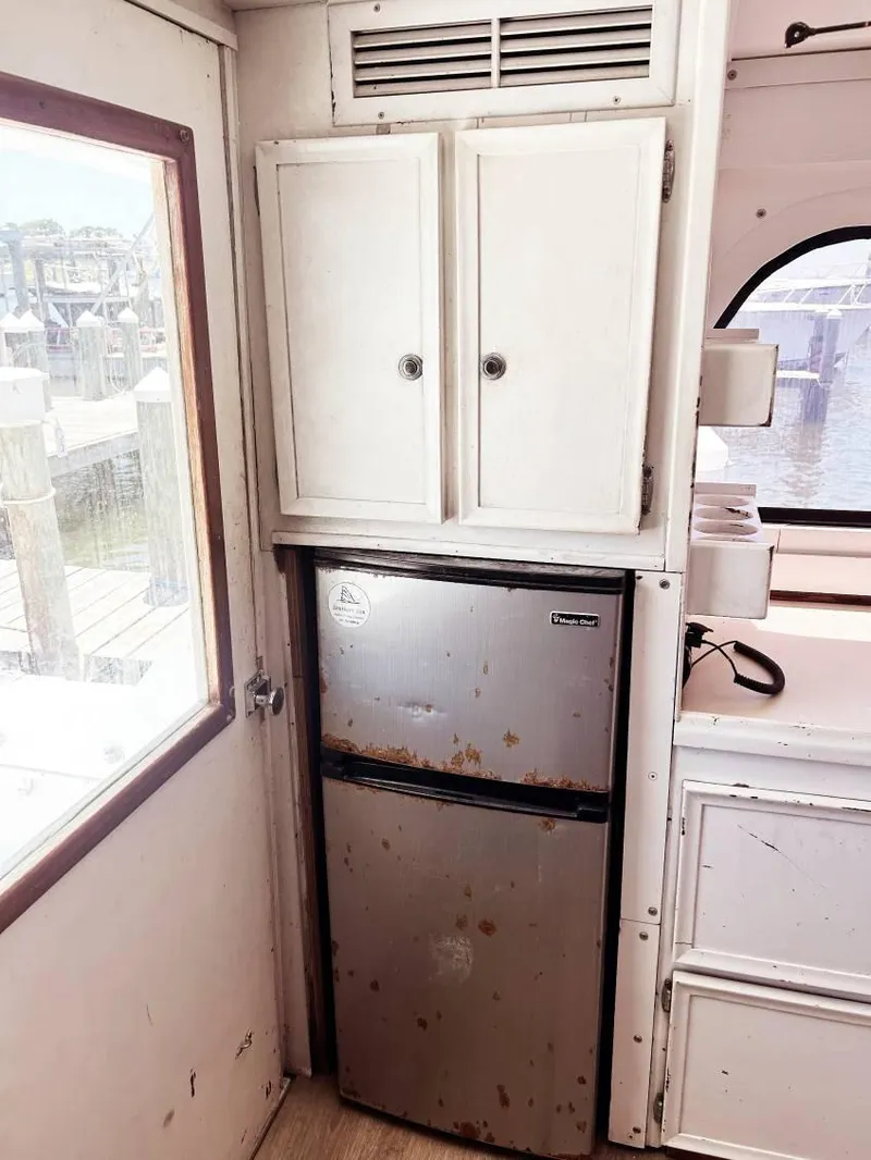 Slide: The Image of 1975 Hatteras 36 Convertible interior with compact fridge and storage cabinets. - 14