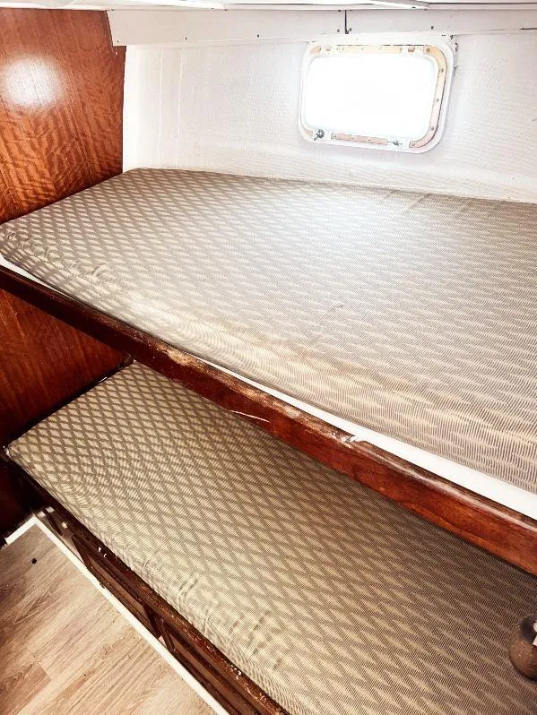 Slide: The Image of 1975 Hatteras 36 Convertible cabin with wooden bunk beds and window. - 16
