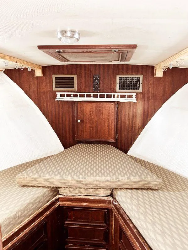 Slide: The Image of 1975 Hatteras 36 Convertible cabin interior with wood paneling and cushioned seating. - 17