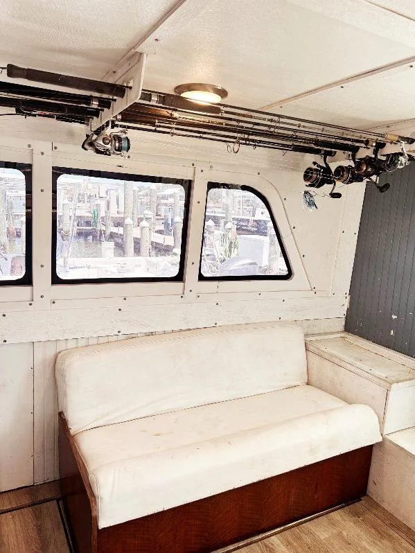 Slide: The Image of Interior of 1975 Hatteras 36 Convertible with white seating and fishing rods. - 19