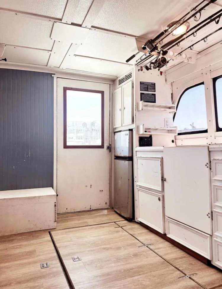 Slide: The Image of Interior of 1975 Hatteras 36 Convertible boat with white cabinetry and wood flooring. - 4