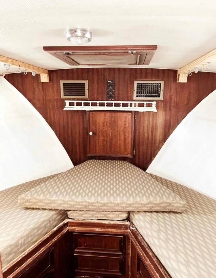Slide: The Image of 1975 Hatteras 36 Convertible cabin interior with wood paneling and cushioned seating. - 7