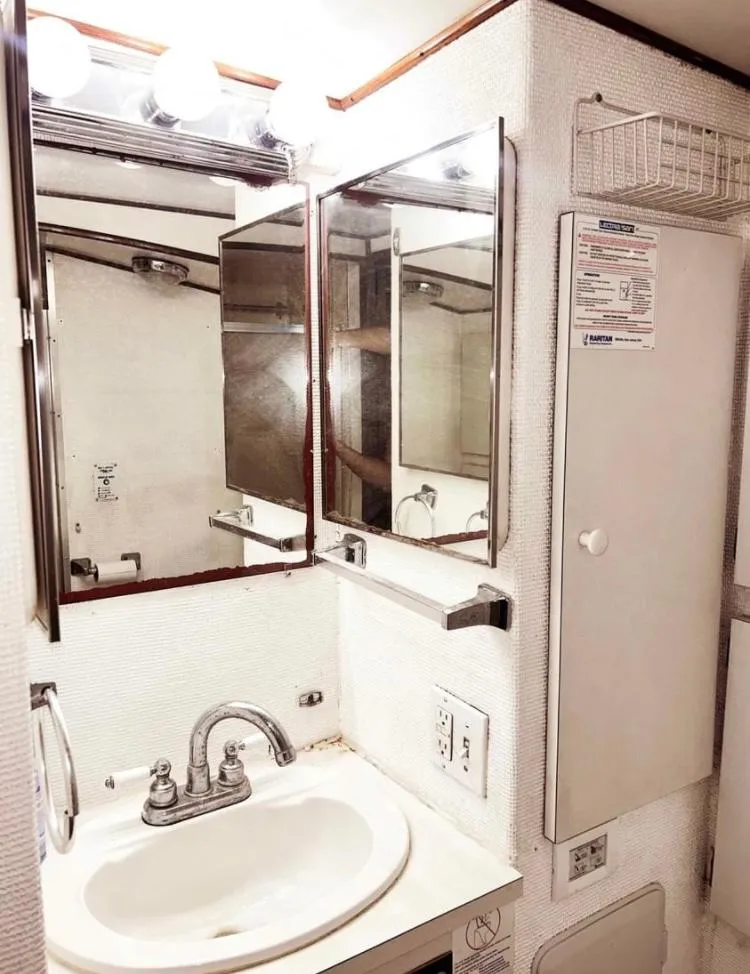 Slide: The Image of 1975 Hatteras 36 Convertible yacht bathroom with sink, mirror, and storage cabinet. - 9