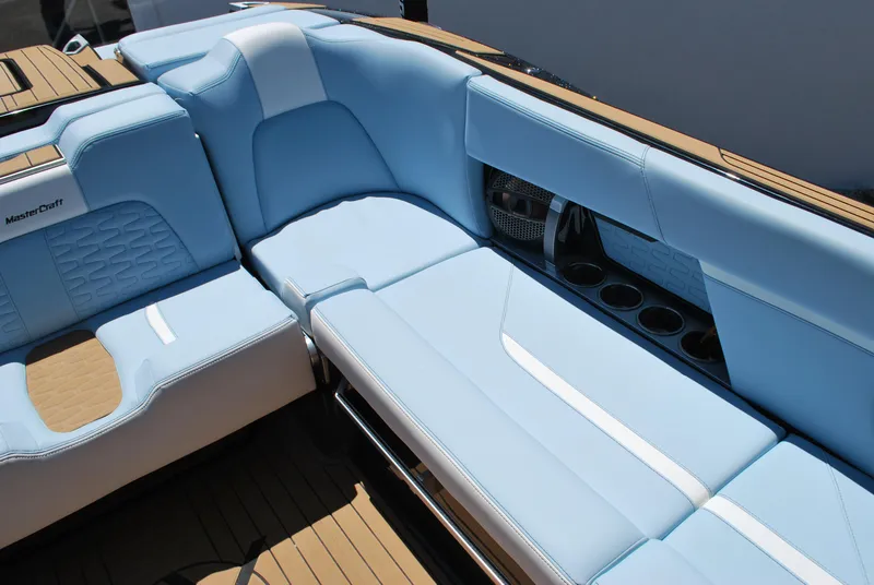 Slide: The Image of 2024 MasterCraft X26 boat interior with light blue seating and cup holders. - 12
