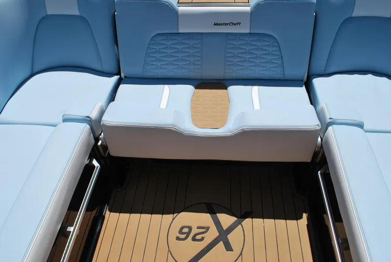 Slide: The Image of 2024 MasterCraft X26 boat interior with light blue seating and teak flooring. - 13