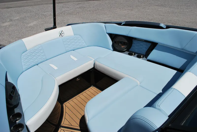 Slide: The Image of 2024 MasterCraft X26 boat interior with light blue seating and wood flooring. - 5