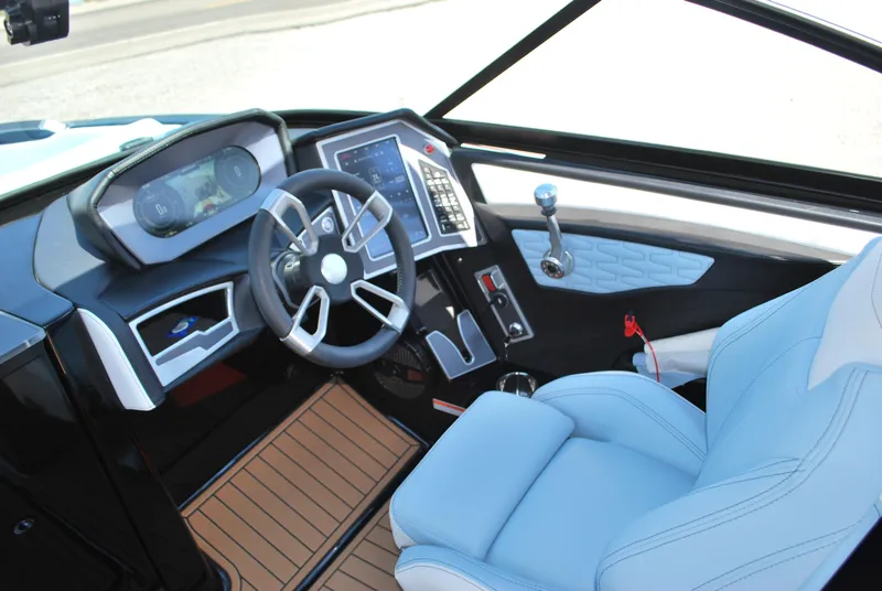 Slide: The Image of 2024 MasterCraft X26 boat interior with modern dashboard and blue seating. - 7