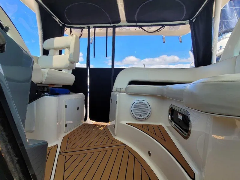 Slide: The Image of Interior of 2013 Pursuit 345 OS Offshore boat with cushioned seating and wood flooring. - 10