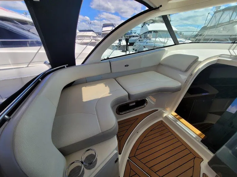 Slide: The Image of 2013 Pursuit 345 OS Offshore boat interior with cushioned seating and wooden flooring. - 11
