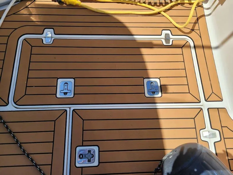 Slide: The Image of Teak deck of 2013 Pursuit 345 OS Offshore boat with metal fixtures and yellow cable. - 22